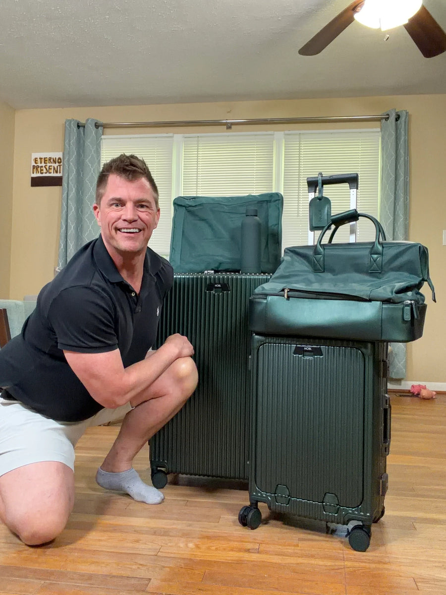 Smiling traveller with green luggage