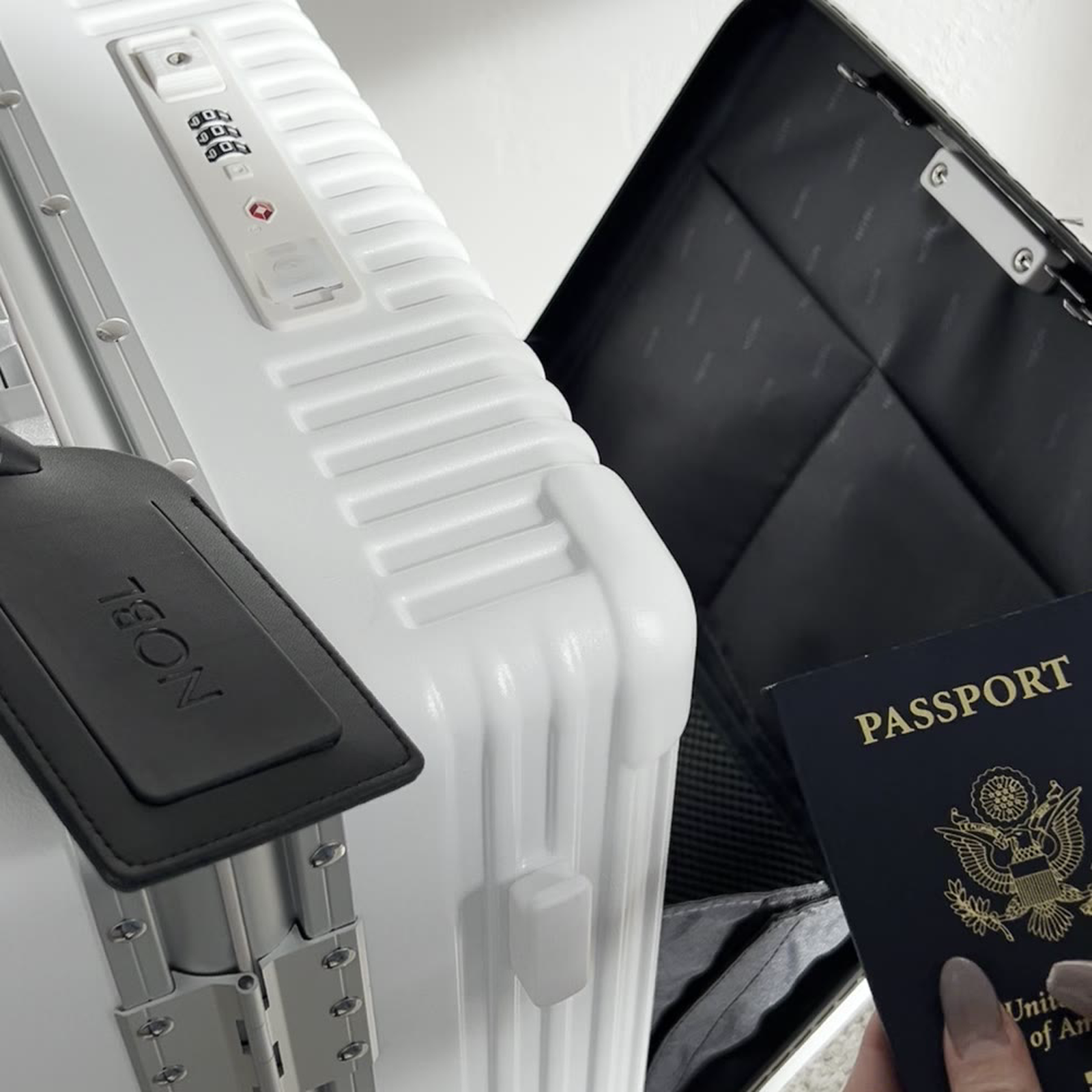 Open front laptop pocket on a green NOBL carry-on for fast airport access